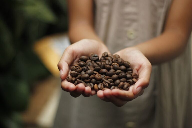 Mujer con granos de café de origen