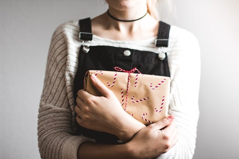 Mujer enviando paquete regalo por Navidad (Kira auf der Heide Unsplash)