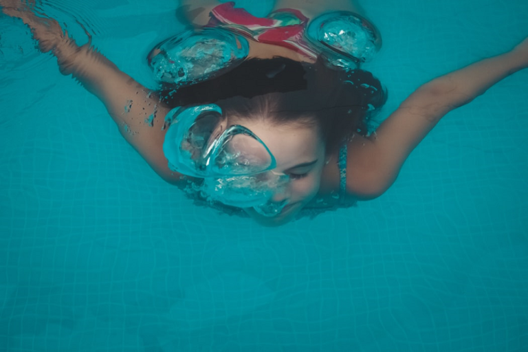 Niña buceando en una piscina